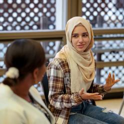 College student in a hijab talking to a group