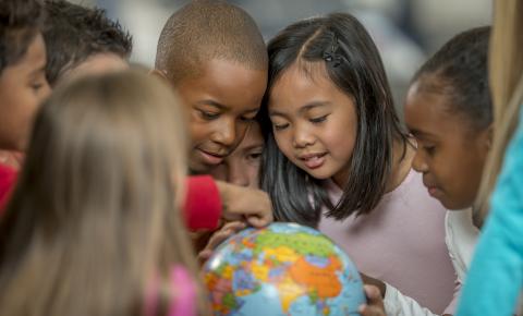 Group of kids looking at a globe