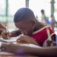 Young student focused intensely on writing.