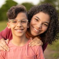 Two siblings smiling at the camera