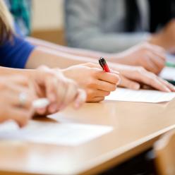 Close up on students' hands as they take a written test