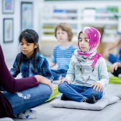 Students meditating in class with their teacher.