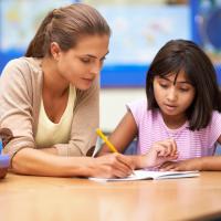 A young woman working with a student on school work