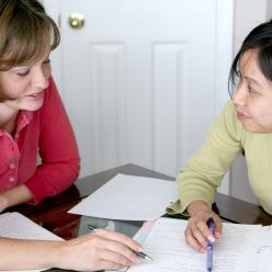 woman working with girl on homework